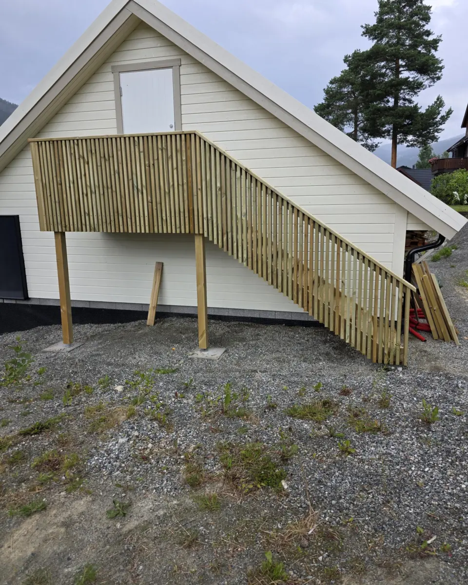 Nytt rekkverk og trapp i tre på hvitt hus